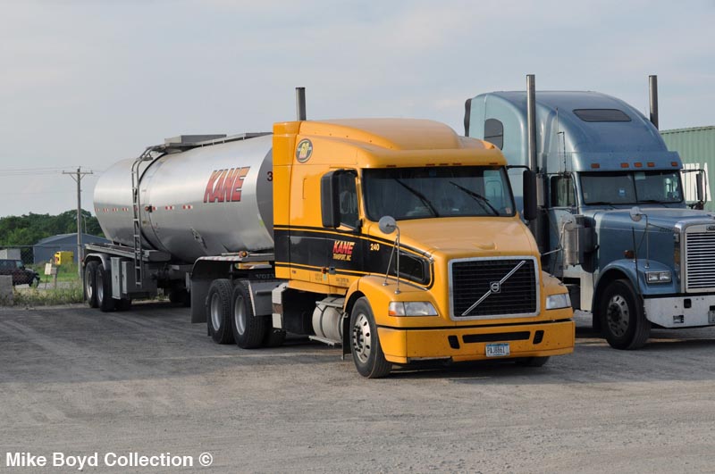 A Kane Transport Volvo VNM430 with a tanker parked at the Shell fuel stop in