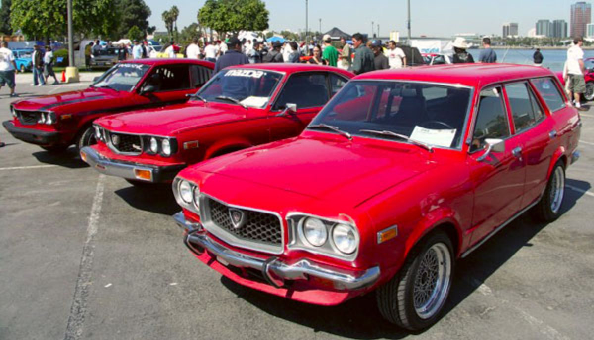 A 1973 Mazda RX-3 wagon, with two other Mazdas in the background.