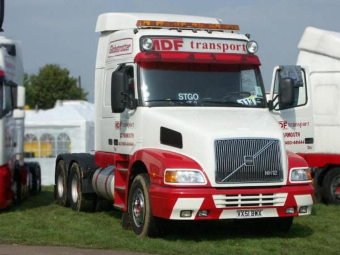 Front right red and white Volvo NH12 truck picture.